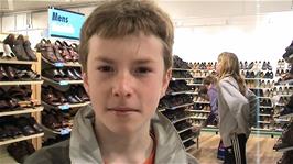 Joe tries to ascertain whether the camcorder is recording in Clarks Shoe Shop, Clarks Village Street, 1.7 miles from the hostel